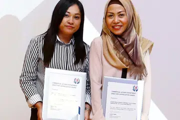 KHIDMAT CEMERLANG: Pegawai khidmat pelanggan Western Union Global Network cawangan Lucky Plaza, Cik Suhartini Sary (kiri), bersama penyelianya Cik Endah Wahyuningsih berjaya melindungi seorang pelanggan daripada menjadi mangsa penipuan penyaluran wang. Usaha mereka diiktiraf dalam Majlis Anugerah Penghargaan CAD di Kompleks Polis Cantonment semalam. - Foto SPF
