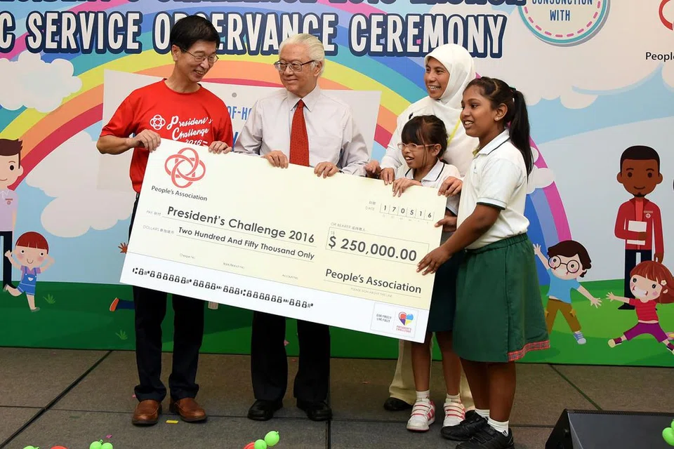 DERMA: Encik Ang Hak Seng (kiri) menyampaikan cek $250,000 kepada Presiden Tony Tan Keng Yam. Bersama mereka ialah pengetua Pusat Rainbow di Margaret Drive, Cik Fauziah Ahmad, dan dua kanak-kanak daripada pusat itu. - Foto PA