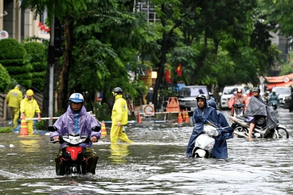 Kenderaan melalui jalan yang banjir akibat hujan lebat susulan Taufan Matmo di Hanoi pada 7 Oktober.