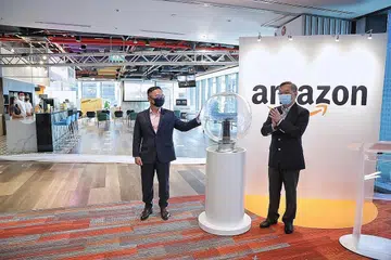 PEJABAT BARU AMAZON: Menteri Perdagangan dan Perusahaan, Encik Gan Kim Yong (kanan), menghadiri pelancaran pejabat baru Amazon di Asia Square semalam. Beliau bersama pengurus negara Amazon Singapore, Encik Henry Low. - Foto BH oleh KEVIN LIM