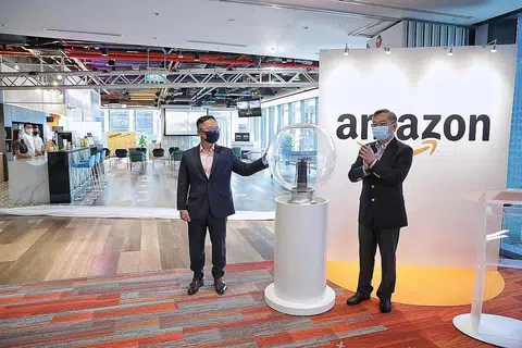 PEJABAT BARU AMAZON: Menteri Perdagangan dan Perusahaan, Encik Gan Kim Yong (kanan), menghadiri pelancaran pejabat baru Amazon di Asia Square semalam. Beliau bersama pengurus negara Amazon Singapore, Encik Henry Low. - Foto BH oleh KEVIN LIM