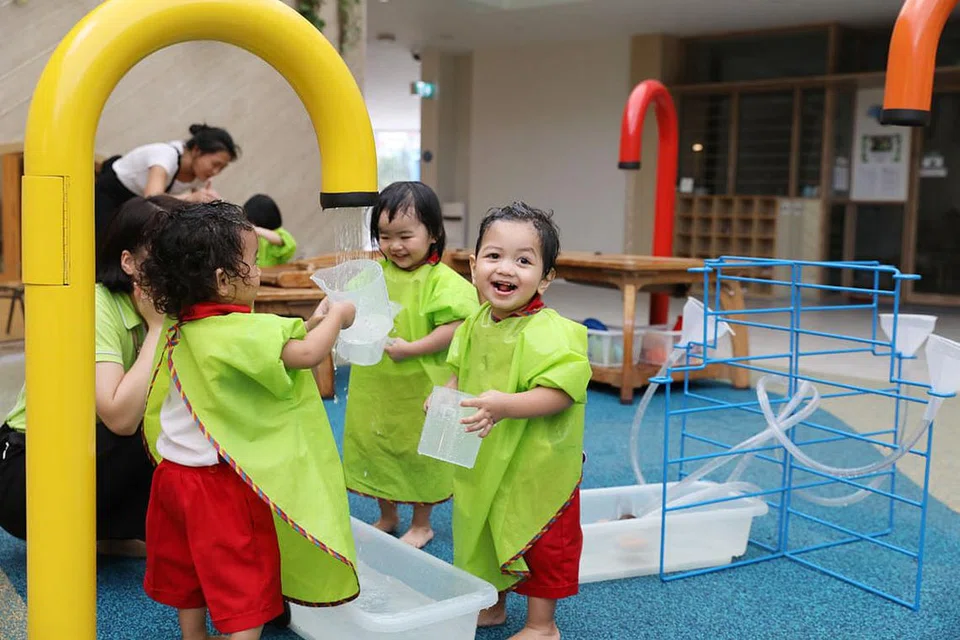 SERONOK BERMAIN DI PAIP PANCURAN AIR: Murid yang mengikuti sesi prasekolah di PCF Sparkletots @ Punggol North tampak begitu asyik di arena bermain air, iaitu antara kemudahan menarik yang terdapat di pusat baru itu. - Foto BH oleh ONG WEE JIN