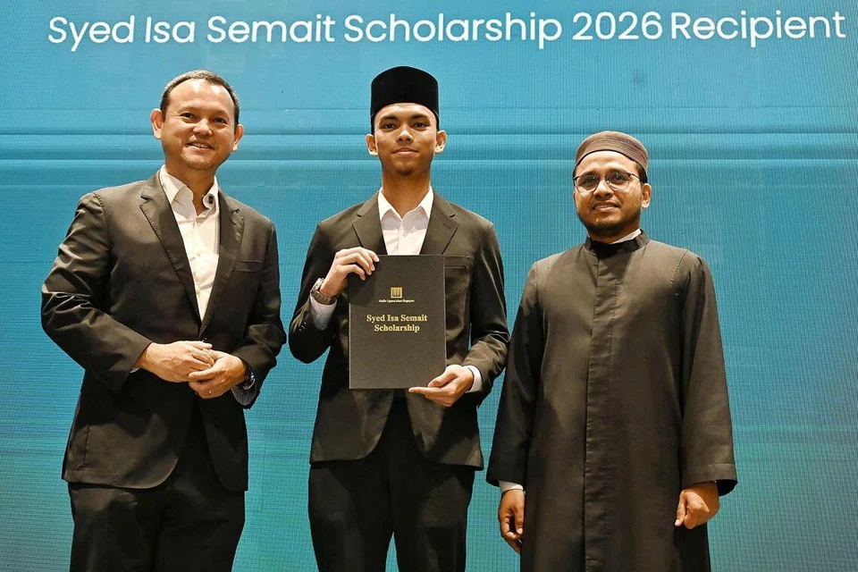 Pelajar Madrasah Aljunied Program Diploma Baccalaureate Antarabangsa, Encik Ahmad Eimran Darwisy Mohammed Suhaimi, 19 tahun, menerima Biasiswa Syed Isa Semait daripada Pemangku Menteri Bertanggungjawab bagi Ehwal Masyarakat Islam, Encik Zaqy Mohamad (kiri) dan Mufti, Dr Nazirudin Mohd Nasir (kanan) pada 20 Julai.