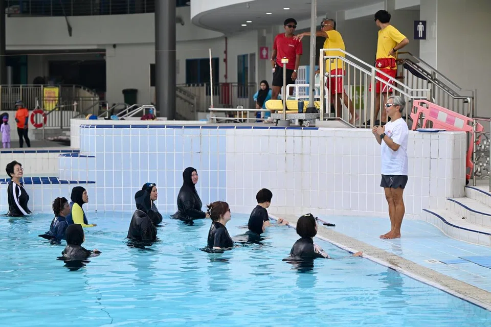 Cik Latipah bersama rakan-rakannya mengikuti gerakan senaman yang dipimpin jurulatih, Encik Desmond Chow, semasa sesi Aqua Fun Fit.