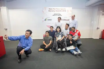 'SELFIE' BERAMAI-RAMAI: Encik Ong Ye Kung (kiri) 'berselfie' bersama sekumpulan atlit-para termasuk Diroy (paling kanan, barisan depan) yang menerima Biasiswa Sukan Para Haw Par kelmarin. Turut dalam gambar ialah Presiden SDCS, Encik Kevin Wong (kiri, barisan belakang) dan Encik Wee Ee Lim (di kiri Encik Wong). - Foto MICHAEL TAN / SDSC