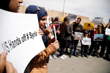 TOLAK CAMPUR TANGAN: Rakyat Syria membuat bantahan terhadap tindakan Amerika Syarikat menyerang negara itu di depan bangunan Pertubuhan Bangsa-Bangsa Bersatu di Damsyik, ibu kota Syria, pada 8 April lalu. - Foto REUTERS