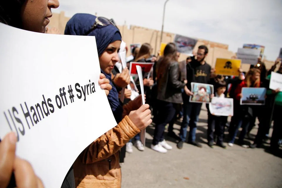 TOLAK CAMPUR TANGAN: Rakyat Syria membuat bantahan terhadap tindakan Amerika Syarikat menyerang negara itu di depan bangunan Pertubuhan Bangsa-Bangsa Bersatu di Damsyik, ibu kota Syria, pada 8 April lalu. - Foto REUTERS