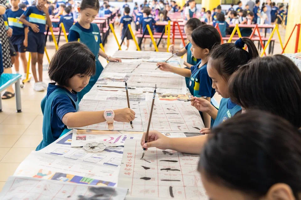 Murid-murid Sekolah Rendah Tampines North cuba tulisan kaligrafi Cina pada Hari Keharmonian Kaum pada 21 Julai.