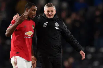 WAJAH BAHAGIA: Pengurus kelab Manchester United asal Norway, Ole Gunnar Solskjaer (kanan) bercakap dengan pemain penyerang pasukannya, Odion Ighalo, di akhir perlawanan pusingan kelima kejohanan Piala FA di mana Red Devils mengalahkan Derby County 0-3 di Stadium Pride Park di Derby, tengah England, kelmarin. - Foto AFP