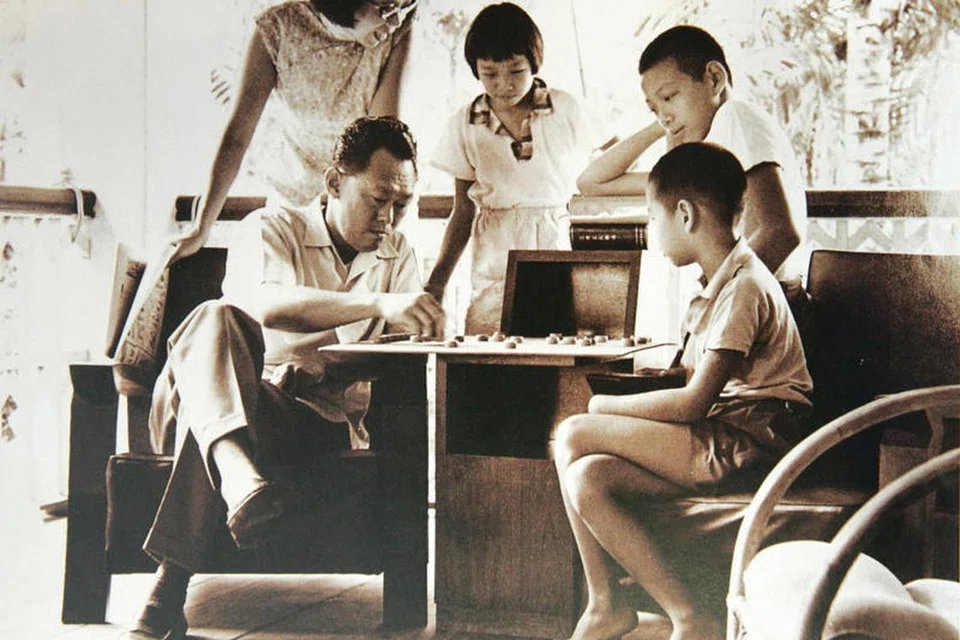 Perdana Menteri, Encik Lee Hsien Loong (dua dari kanan, di belakang), bermain catur dengan bapanya, Perdana Menteri pertama, mendiang Encik Lee Kuan Yew (duduk, kiri) sambil diperhatikan adik-beradik, Encik Lee Hsien Yang (duduk, kanan), Cik Lee Wei Ling, dan ibu mereka, Cik Kwa Geok Choo. 