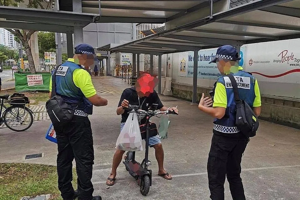 PENDEKATAN TEGAS: Pegawai penguatkuasa LTA kelihatan sedang memeriksa alat mobiliti peribadi (PMD) seorang pengguna. Mereka yang didapati bersalah boleh didenda sehingga $2,000, dipenjara hingga tiga bulan atau kedua-duanya. - Foto LTA