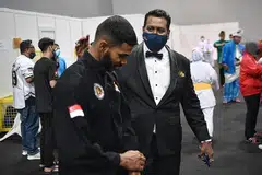 BERJUANG HEBAT UNTUK MENANGI: Jaguh silat negara, Sheik Farhan (kiri), mendapat kata-kata semangat daripada Sheik selepas berjuang sengit sebelum menewaskan pesaingnya dari Vietnam dalam final acara tanding putera J. 