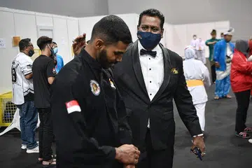 BERJUANG HEBAT UNTUK MENANGI: Jaguh silat negara, Sheik Farhan (kiri), mendapat kata-kata semangat daripada Sheik selepas berjuang sengit sebelum menewaskan pesaingnya dari Vietnam dalam final acara tanding putera J. 