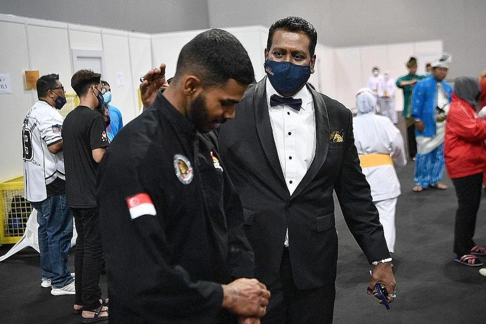 BERJUANG HEBAT UNTUK MENANGI: Jaguh silat negara, Sheik Farhan (kiri), mendapat kata-kata semangat daripada Sheik selepas berjuang sengit sebelum menewaskan pesaingnya dari Vietnam dalam final acara tanding putera J. 