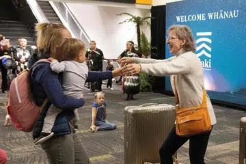 KEMBALI BERSATU: Keluarga kembali bertaut selepas pengunjung yang menaiki pesawat dari Sydney, Australia, tiba di Wellington, New Zealand, sebaik sempadan rentas-Tasman dibuka semula bagi perjalanan bebas kuarantin antara kedua-dua negara. - Foto AFP 