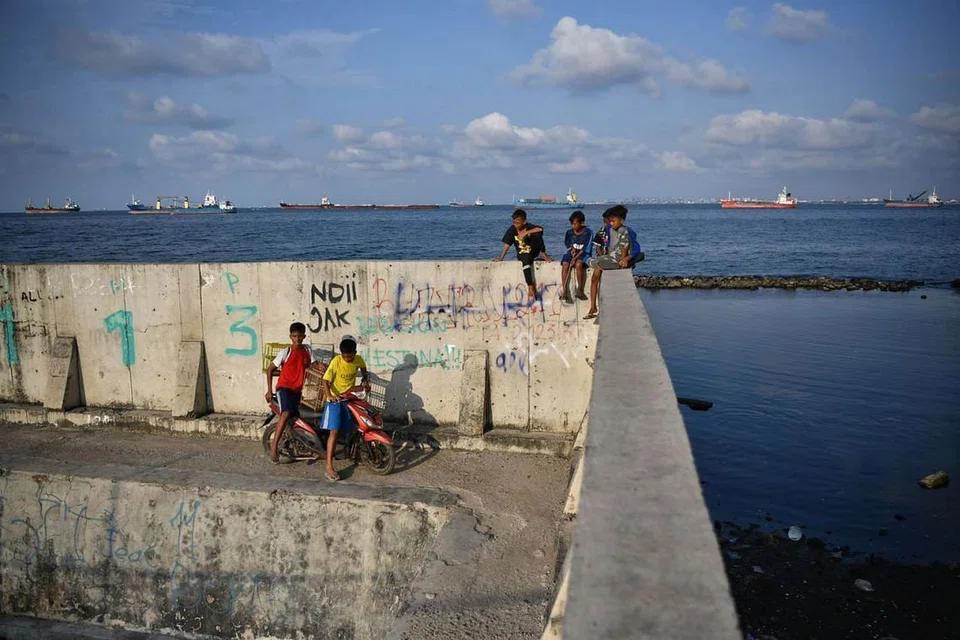 HALANG KE LAUT: Tembok setinggi dua meter membantu menghalang air laut masuk, tetapi menutup akses ke laut bagi penduduk di Muara Baru di Jakarta Utara. - Foto THE STRAITS TIMES