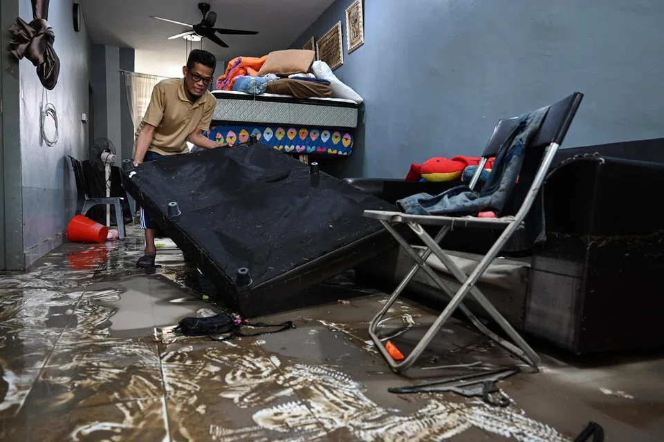 Seorang penduduk yang terjejas giat melakukan kerja pembersihan di kediamannya di Rumah Mampu Milik Teluk Kalong, Kemaman, Terengganu, pada 20 November, selepas banjir surut pada sebelah petang.