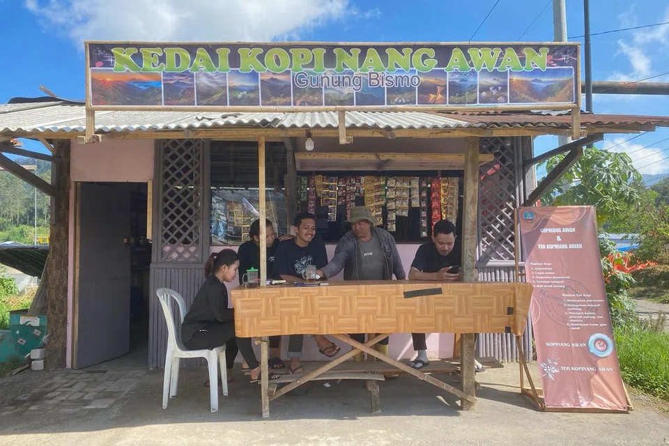 HASIL SAMPINGAN: Selain bertani kopi, Encik Miyanto (dua dari kanan) melayan pelanggan di gerai kopinya di kaki Gunung Bismo di Dataran Tinggi Dieng, Jawa Tengah