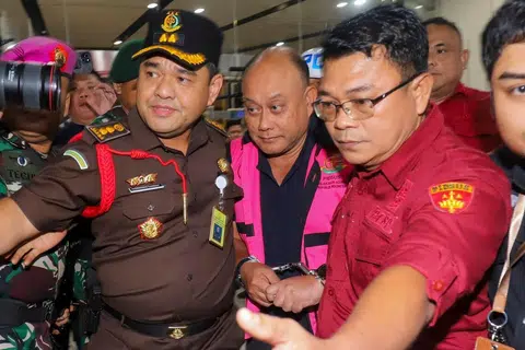 Dadan Hindayana (tengah), bekas ketua program makanan percuma sekolah Indonesia, diiringi pegawai Pejabat Peguam Negara dan anggota tentera Indonesia ketika meninggalkan bangunan Pejabat Peguam Negara di Jakarta pada 3 Jun 2026 selepas disoal siasat berhubung dakwaan penyelewengan dalam pelaksanaan program tersebut.