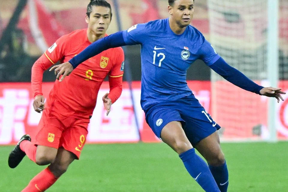 Pemain pertahanan Singapura, Irfan Fandi (kanan) ketika beraksi dalam perlawanan kelayakan Piala Dunia menentang China di Stadium Pusat Olimpik Tianjin pada 26 Mac. 