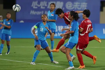 CUBA PERTAHANKAN: Pasukan bola sepak wanita Singapura (jersi biru) bergelut mempertahankan hantaran lintang dan sepakan penjuru dari skuad Korea Utara dalam perlawanan pembukaan Sukan Asia Hangzhou di Stadium Pusat Sukan Wenzhou pada Ahad. 
