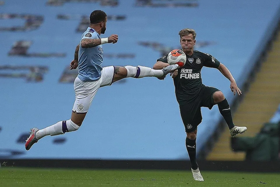 BERAKSI: Pemain Manchester City, Kyle Walker (kiri) dan pemain Newcastle, Matt Ritchie cuba mendapatkan bola dalam perlawanan di Stadium Ethihad . - Foto EPA-EFE