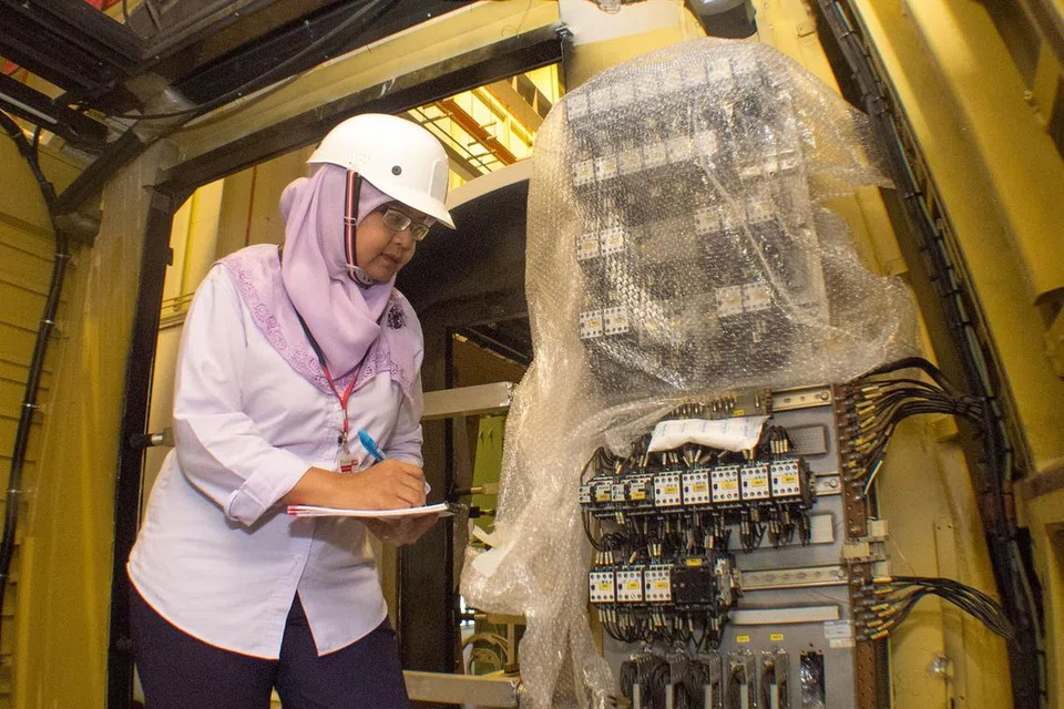 PAKAR 'MRT': Cik Azizah Sapari melakukan pemeriksaan terhadap sebuah unit dalam gerabak MRT yang sedang menjalani kerja pemfabrikatan. - Foto ihsan AZIZAH SAPARI