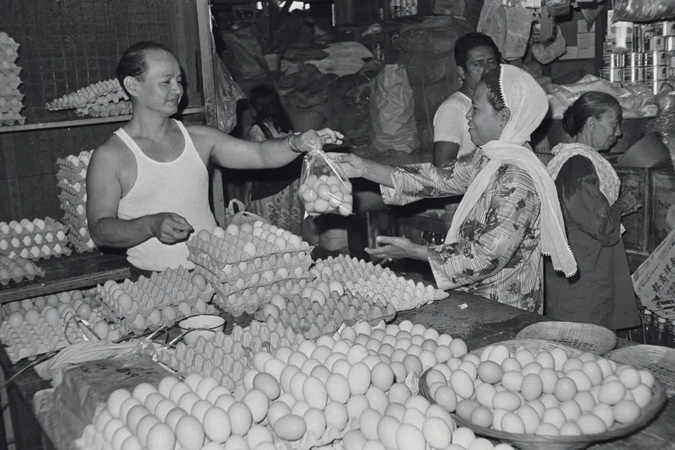Seorang wanita membeli telur di pasar basah di Singapura, menjelang Hari Raya Aidilfitri dalam gambar yang dipetik pada Ogos 1979 ini. 