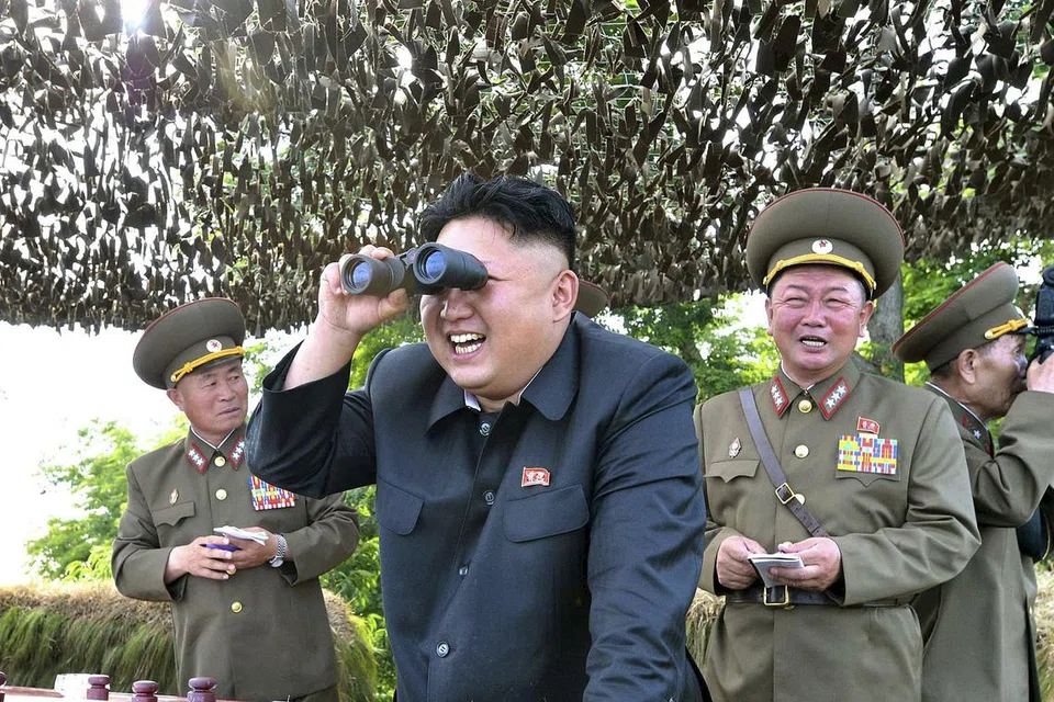 LANGGAR RESOLUSI PBB: Gambar fail pemimpin Korea Utara, Encik Kim Jong Un, melihat dengan teropong ketika memeriksa pangkalan Hwa Islet di bahagian timur semenanjung Korea. Pyongyang dikatakan melancarkan dua peluru berpandu jarak sederhana ke Laut Jepun kelmarin. - Foto REUTERS