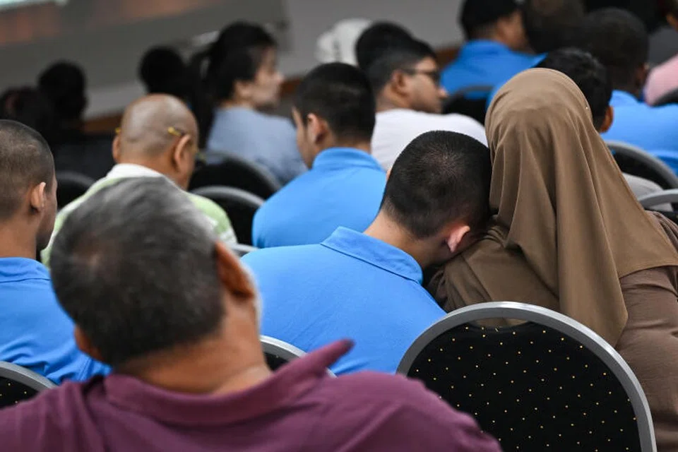 Pelatih pemulihan ‘Fai’ (dua dari kanan) bersandar di atas bahu neneknya (paling kanan) semasa Majlis Epilog Pusat Latihan Pemulihan (RTC) pada 21 Ogos.