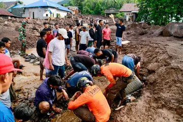 Pasukan penyelamat bersama penduduk mencari mangsa banjir kilat yang melanda kampung di Ternate, Maluku Utara, dek hujan berlarutan, pada 25 Ogos. 