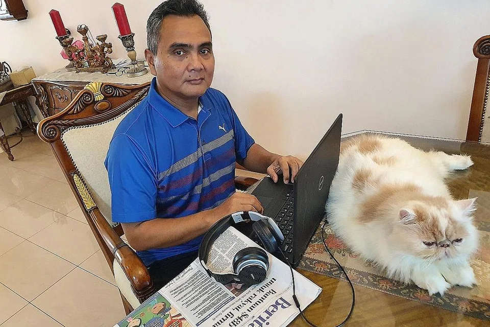 LAIN DI PEJABAT, LAIN DI RUMAH: Penulis, yang ditemani kucing kesayangannya, Hippo, akur terpaksa membuat beberapa penyesuaian dalam urusan kerja seperti bergantung kepada WhatsApp dan Google Hangout untuk bermesyuarat. - Foto ihsan NAZRY MOKHTAR