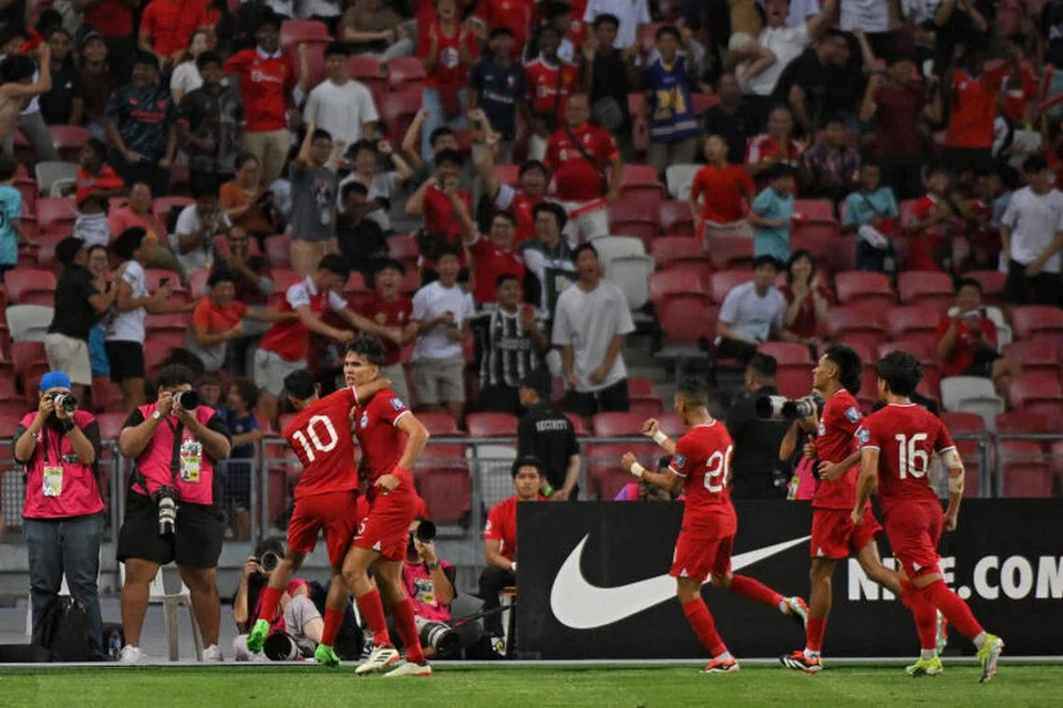 Pemain Singapura meraikan gol Jacob Mahler (empat dari kanan), yang membantu pasukan Singa menyekat China 2-2 dalam aksi kelayakan Piala Dunia di Stadium Negara pada 21 Mac. 