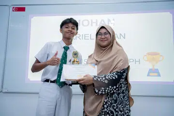 Pemenang peraduan, ‘Saya Boleh Berpidato’, bagi Kategori B untuk pelajar Menengah 3 hingga 5, Ariel Aiman Noorisman (kiri), dari Institusi St. Joseph (SJI) bersama pengasas Pusat Bahasa Nusa, Cik Hayati Abdullah.
