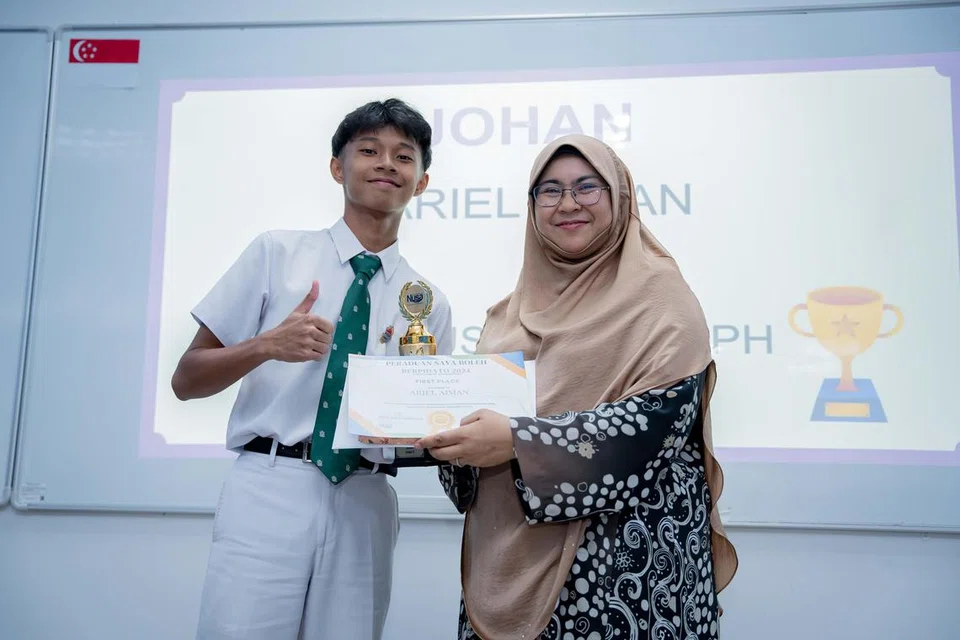 USAHA KOLEKTIF: Pemenang peraduan ‘Saya Boleh Berpidato’, bagi Kategori B, Ariel Aiman Noorisman (kiri), dari Institusi St. Joseph (SJI) yang bergambar bersama pengasas Pusat Bahasa Nusa, Cik Hayati Abdullah, berkata kemenangannya melibat gabungan usaha ibu bapa, guru dan rakan.