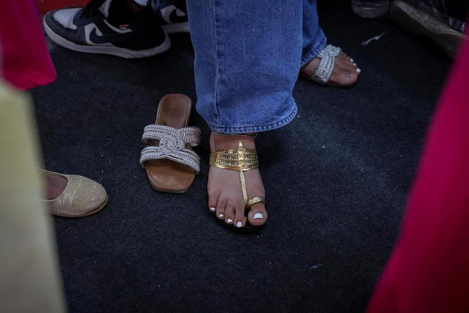 Seorang wanita mencuba sandal Kolhapuri, iaitu kasut tradisional etnik India, di sebuah kedai di New Delhi.