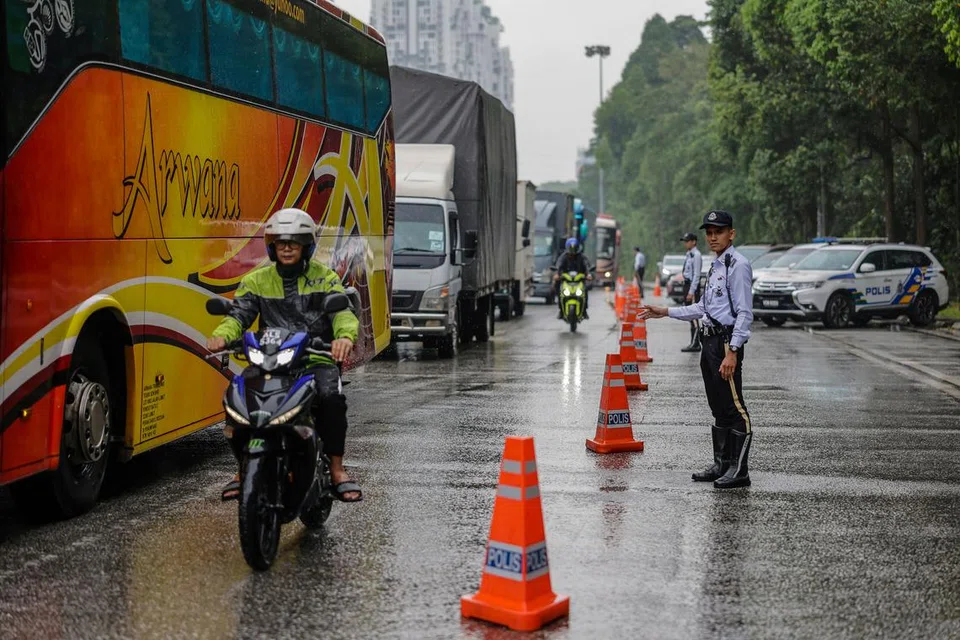 KAWAL LALU LINTAS: Anggota polis trafik mengawal aliran trafik di Plaza Tol Jalan Duta yang mulai sesak apabila penduduk ibu kota Kuala Lumpur mula pulang ke kampung halaman sempena sambutan Aidilfitri. 