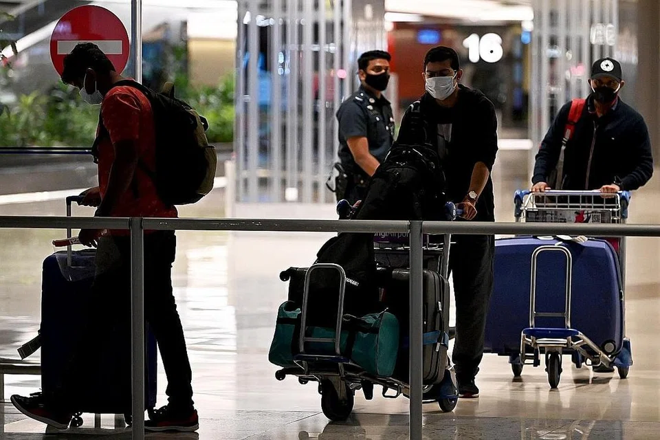 SEKTOR PENERBANGAN TERJEJAS: Beberapa penumpang kelihatan menyorong beg di Lapangan Terbang Changi. Sektor penerbangan antara yang teruk terjejas dek Covid-19 - Foto fail