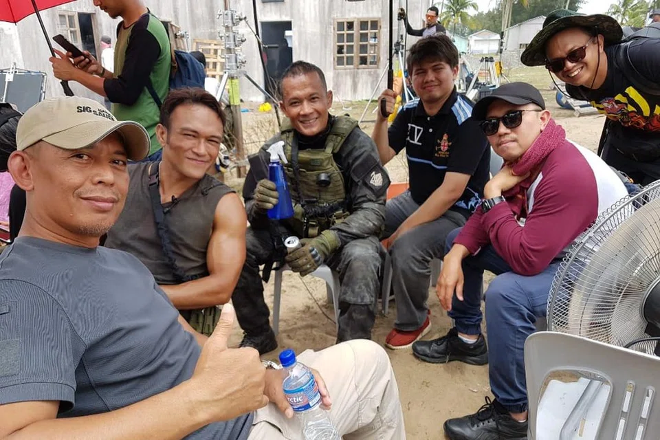 REHAT SEBENTAR: Encik Mohd Raziff (paling kiri) kelihatan bergambar bersama Shahiezy (dua dari kiri) dan Jeff Catz (tiga dari kiri) bersama kru semasa rakaman Polis Evo 2.