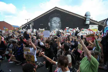 SOKONGAN KEPADA RASHFORD: Penunjuk perasaan anti-perkauman berkumpul di mural Marcus Rashford di Manchester yang diconteng. - Foto AFP