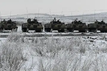 SALING ADAKAN LATIHAN TENTERA: Seorang askar Ukraine mengacukan senjata antikereta kebal yang dibekalkan Britain kelmarin sedang Russia pula mengadakan latihan melibatkan kenderaan berperisai jenis BMP-3 (gambar atas) di daerah Rostov pada hari yang sama. - Foto REUTERS