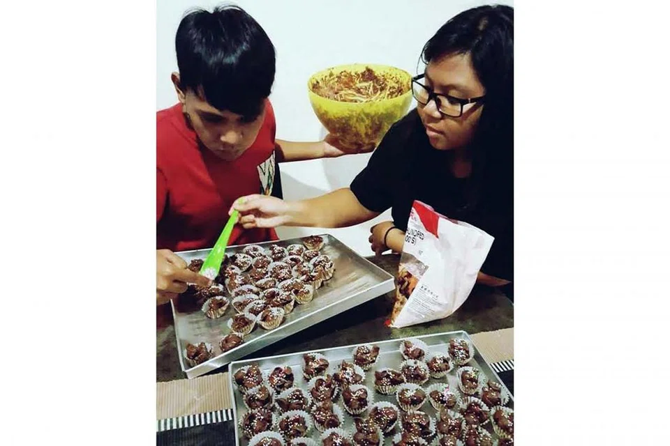 SEMANGAT GOTONG-ROYONG: Meskipun mudah untuk mendapatkan kuih Raya yang dijual di pasar raya dan bazar Ramadan kini, sesetengah anggota masyarakat tetap memilih untuk membuat kuih Raya sendiri bersama keluarga di rumah. - Foto JUJULEUPHORIC