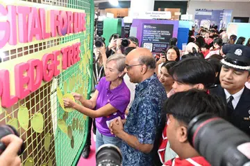Presiden Tharman Shanmugaratnam (dua dari kiri) dan Menteri Penerangan dan Pembangunan Digital, Cik Josephine Teo, meninjau kegiatan yang diadakan sempena Festival Digital Sepanjang Hayat (DfL) di VivoCity pada 24 Oktober.