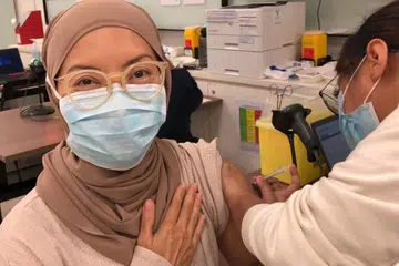 MENERIMA SUNTIKAN VAKSIN: Dr Elly Sabrina Ismail, mendapati proses pemberian suntikan dos pertama vaksin Covid-19 Pfizer-BioNTech di Poliklinik Bukit Batok pada 14 Januari lalu cepat dan senang. Anggota sektor perubatan itu merupakan antara kumpulan pertama yang mendapatkan vaksin berkenaan di sini. - Foto ihsan ELLY SABRINA ISMAIL