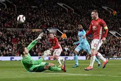 GOL: Penyerang Manchester United Wayne Rooney (kanan) menendang bola melepasi penjaga gawang Feyenoord Brad Jones (kiri) bagi gol pertama pasukannya dalam perlawanan di Stadium Old Trafford kelmarin. - Foto AFP