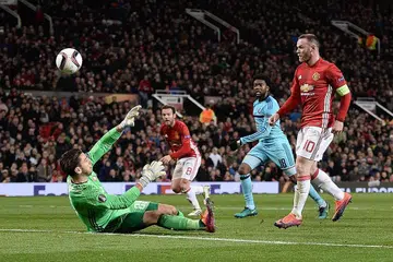 GOL: Penyerang Manchester United Wayne Rooney (kanan) menendang bola melepasi penjaga gawang Feyenoord Brad Jones (kiri) bagi gol pertama pasukannya dalam perlawanan di Stadium Old Trafford kelmarin. - Foto AFP