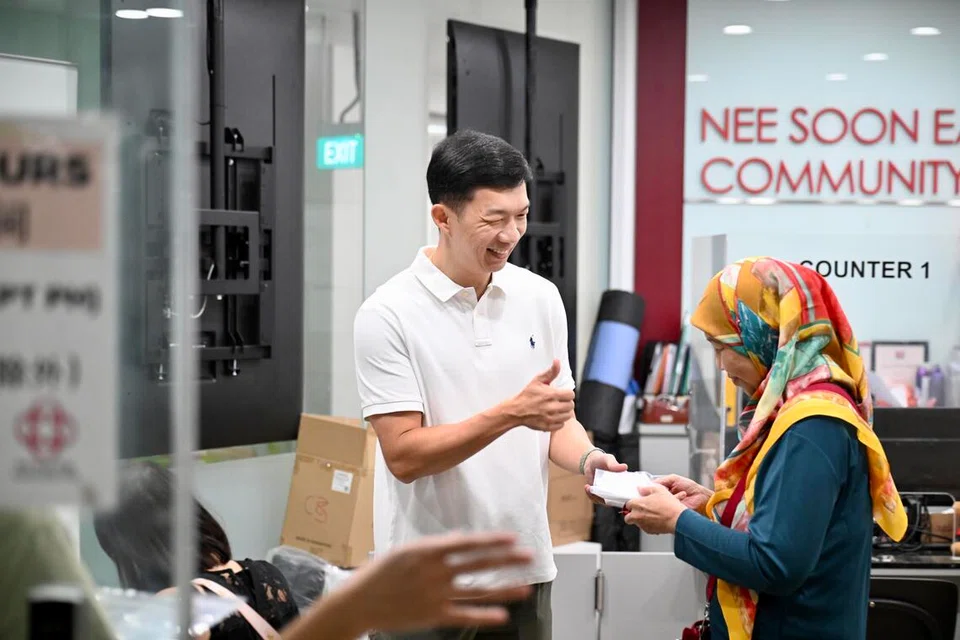 Anggota Parlimen (AP) GRC Nee Soon, Encik Jackson Lam (kiri), telah turun padang di Kelab Masyarakat Nee Soon East pada 15 Oktober untuk membantu proses pengambilan pelitup bagi rakyat yang layak seperti Cik Sutedjowatie Soedarto, 66 tahun (kanan).