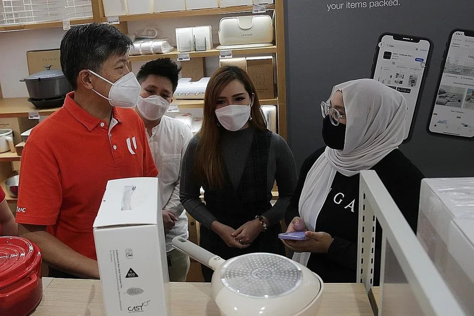 LAWATAN LIHAT LEBIH DEKAT: Encik Ng (kiri, gambar kiri) bertemu dengan kakitangan cawangan runcit IUIGA, termasuk Cik Siti Suhaimah Sairi (kanan), di PLQ Mall semalam untuk memahami operasi runcit mereka. - Foto BH oleh GIN TAY