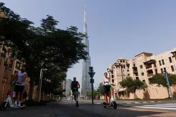 Orang ramai menunggang skuter di jalanan dekat Burj Khalifa, selepas serangan Iran ke atas Dubai, Amiriah Arab Bersatu (UAE), pada 1 Mac 2026.