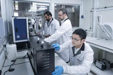 TERBARU: (Dari kiri) Dr Govindan Kutty Rajendran Nair, Dr Sergio G. Echeverrigaray dan Dr Yang Jie bekerja di bilik kering yang terdapat di Makmal Bateri baru di NUS.